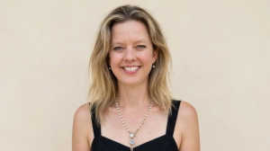 Dr Hannah Terry smiles at the camera. She has blonde hair and is wearing a black dress.