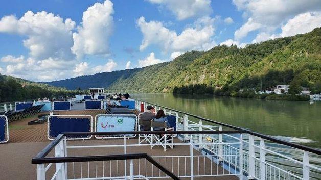 A picture taken from the top deck of a river cruise vessel, as it moves along the Danube.