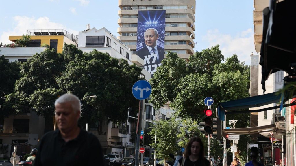 A large banner hung from a tower block in Tel Aviv, Israel, shows Israeli Prime Minister Benjamin Netanyahu with the Hebrew phrase, "We will not surrender" (6 October 2026)